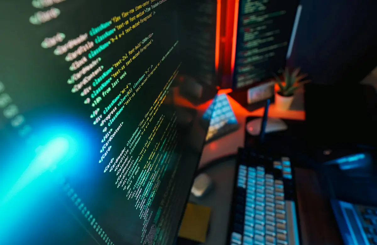 A computer screen in a high-tech office displays colourful source code.