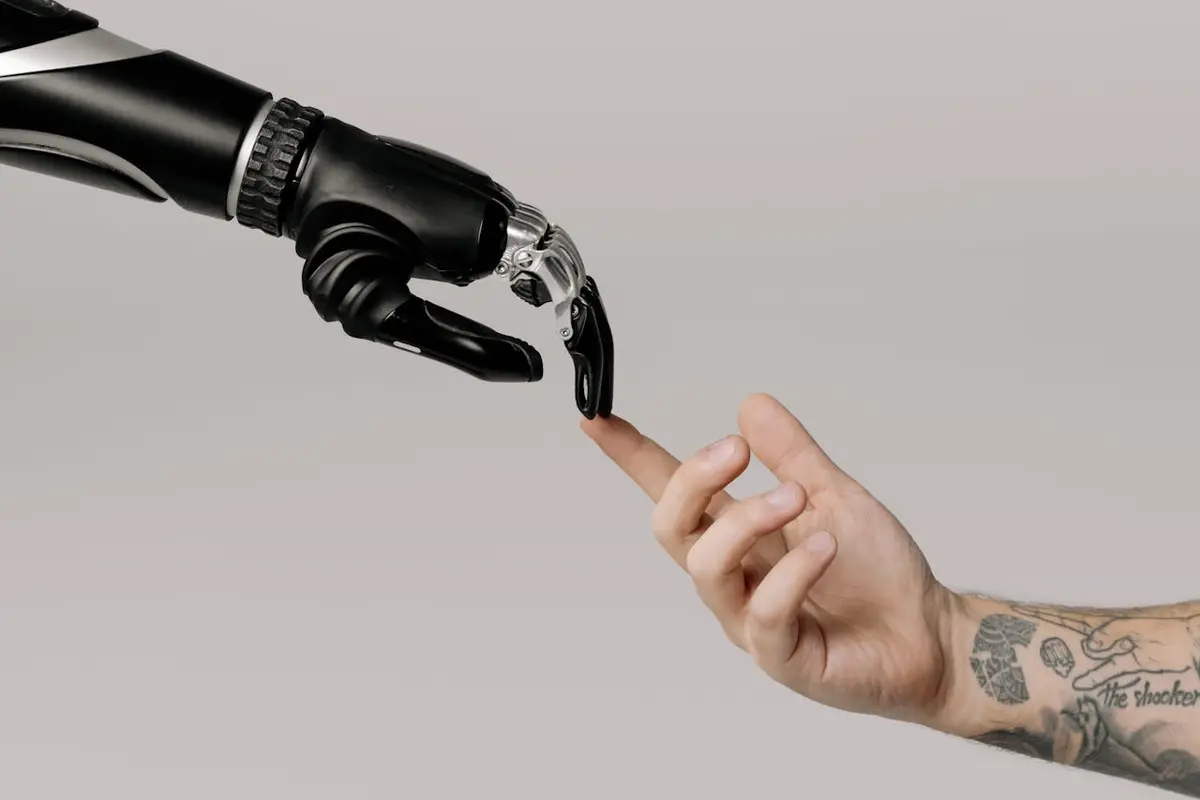 A robotic arm and a human arm touch fingertips