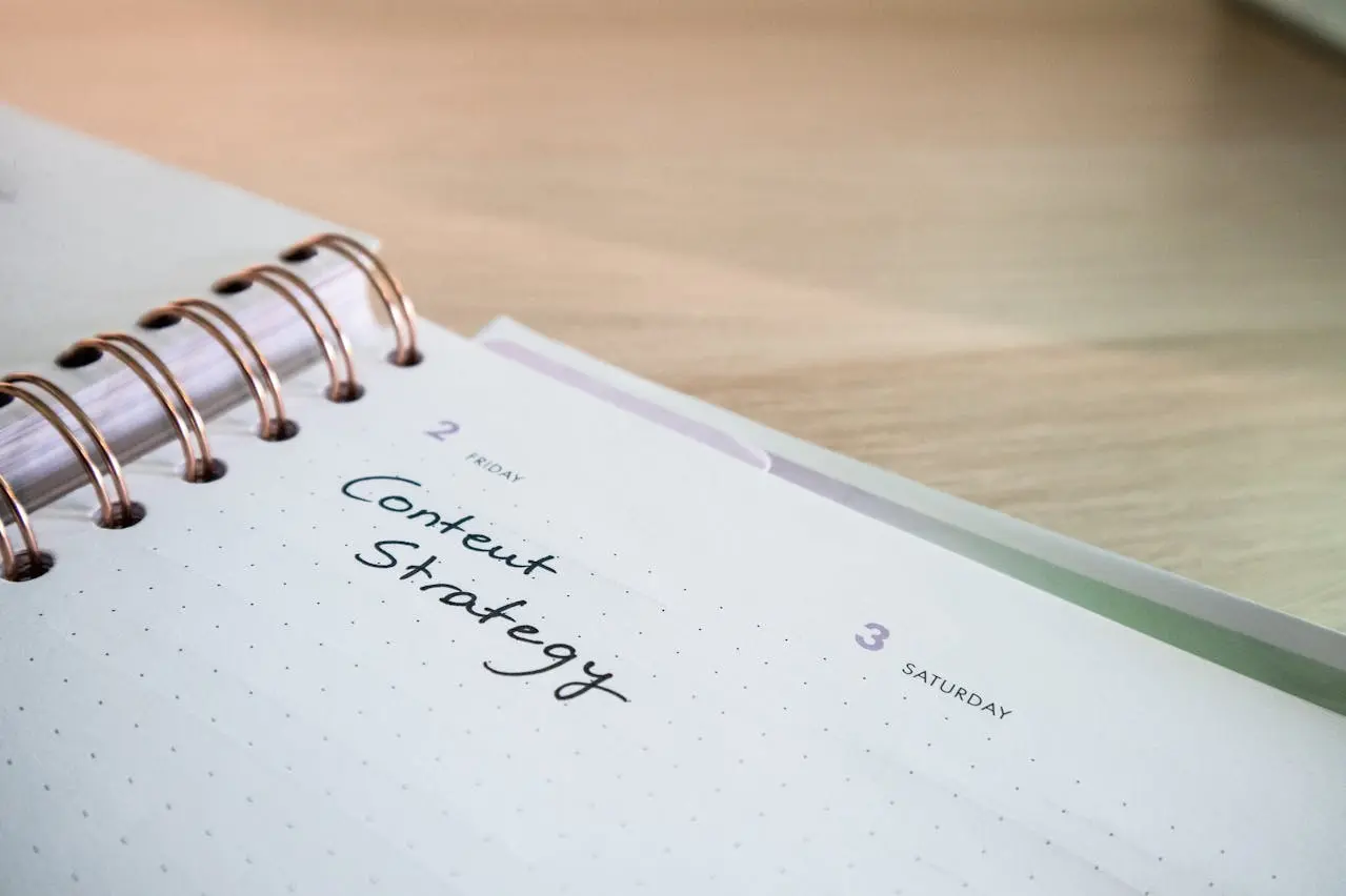 A spiral-bound notebook is open with 'Content Strategy' written on the current page