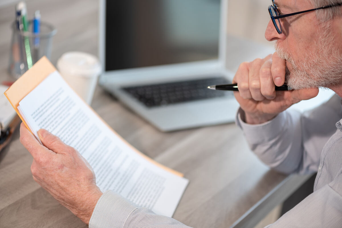 A lawyer carefully reviews a printed legal document.