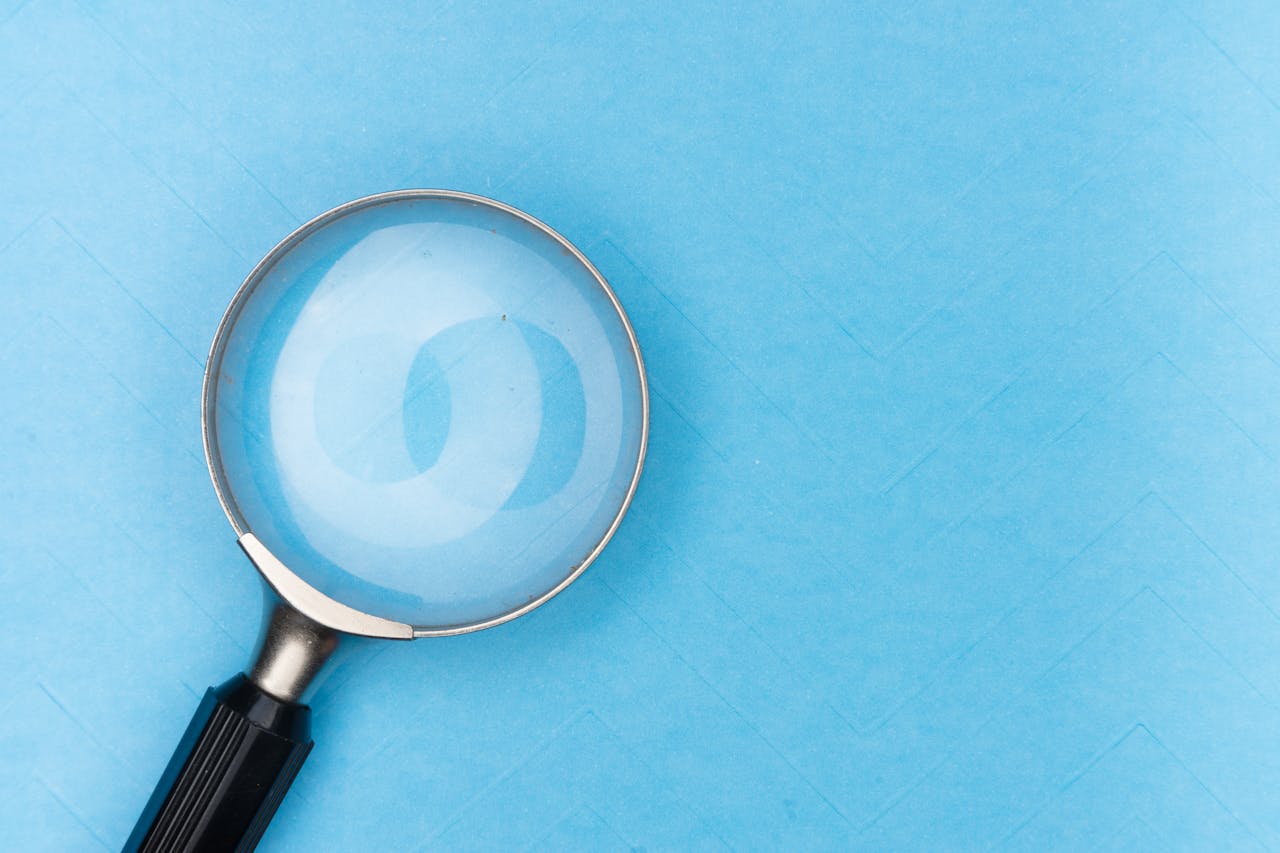 A magnifying glass focuses on a blank canvas.