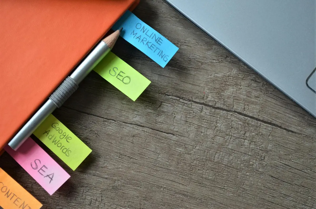 Close-up of a notebook with colourful tabs with various online marketing terms written on them