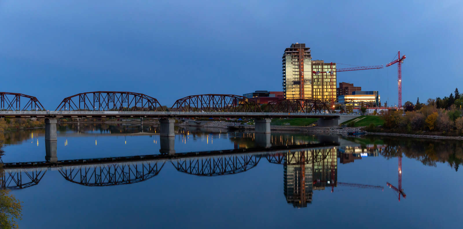 Bridge over the river in downtown Saskatoon, Saskatchewan during a vibrant sunrise.