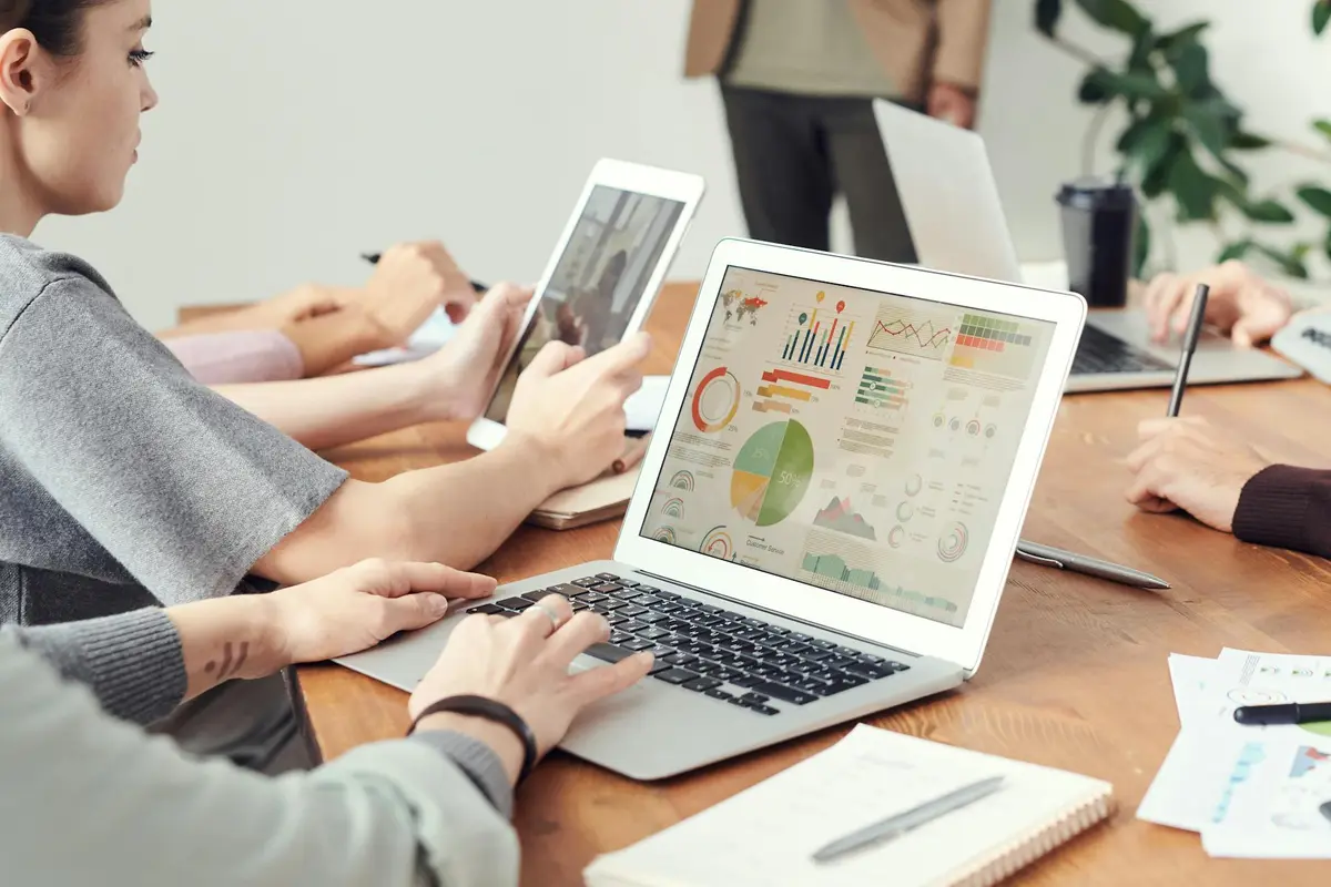 A laptop screen displays a dashboard containing various SEO metrics, with colourful charts and graphs