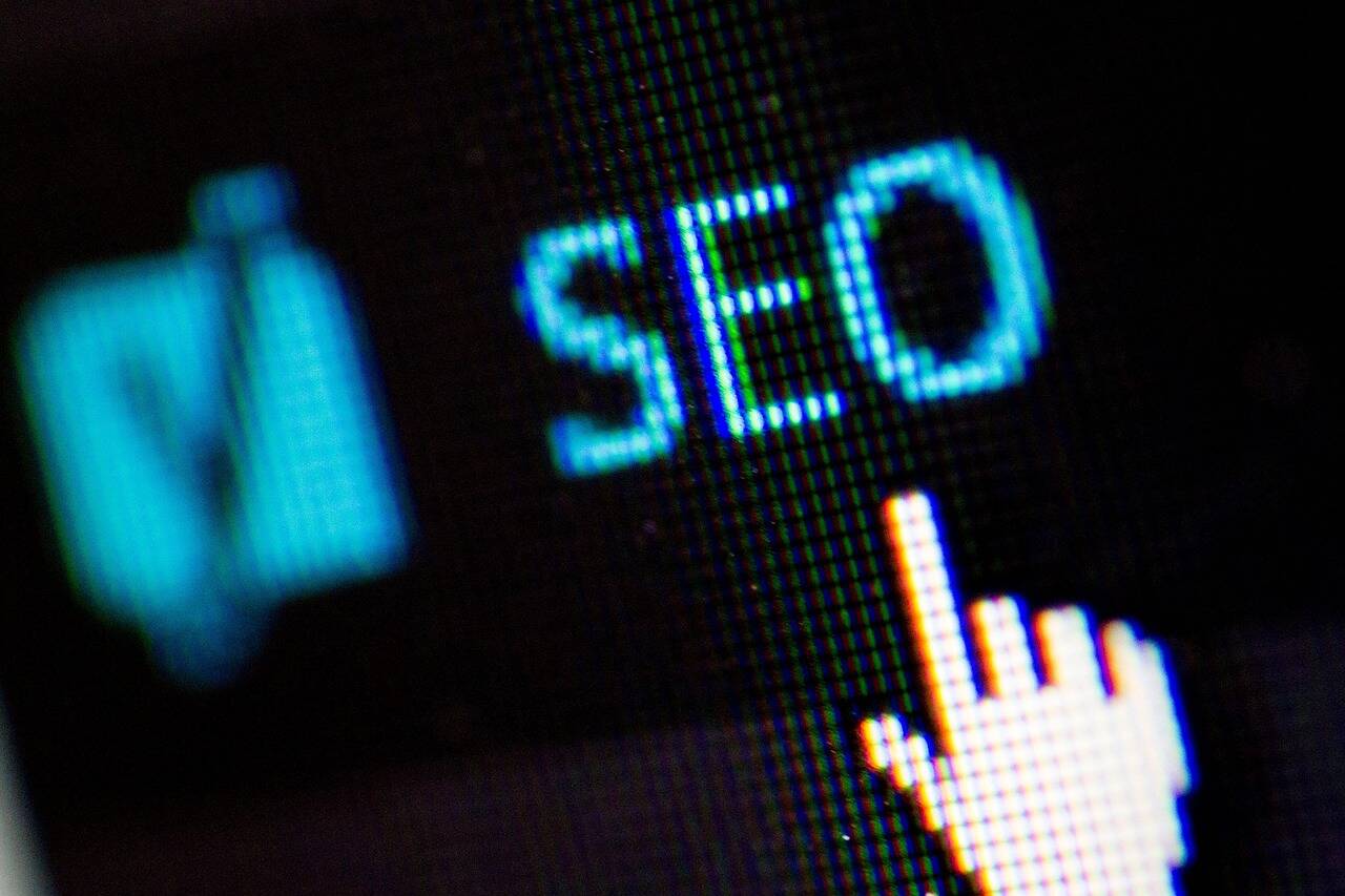 A mouse pointer hovers over the letters "SEO" on a black screen