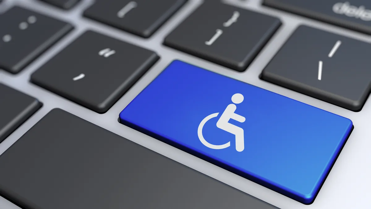 Computer keyboard with a blue key showing the wheelchair accessibility symbol