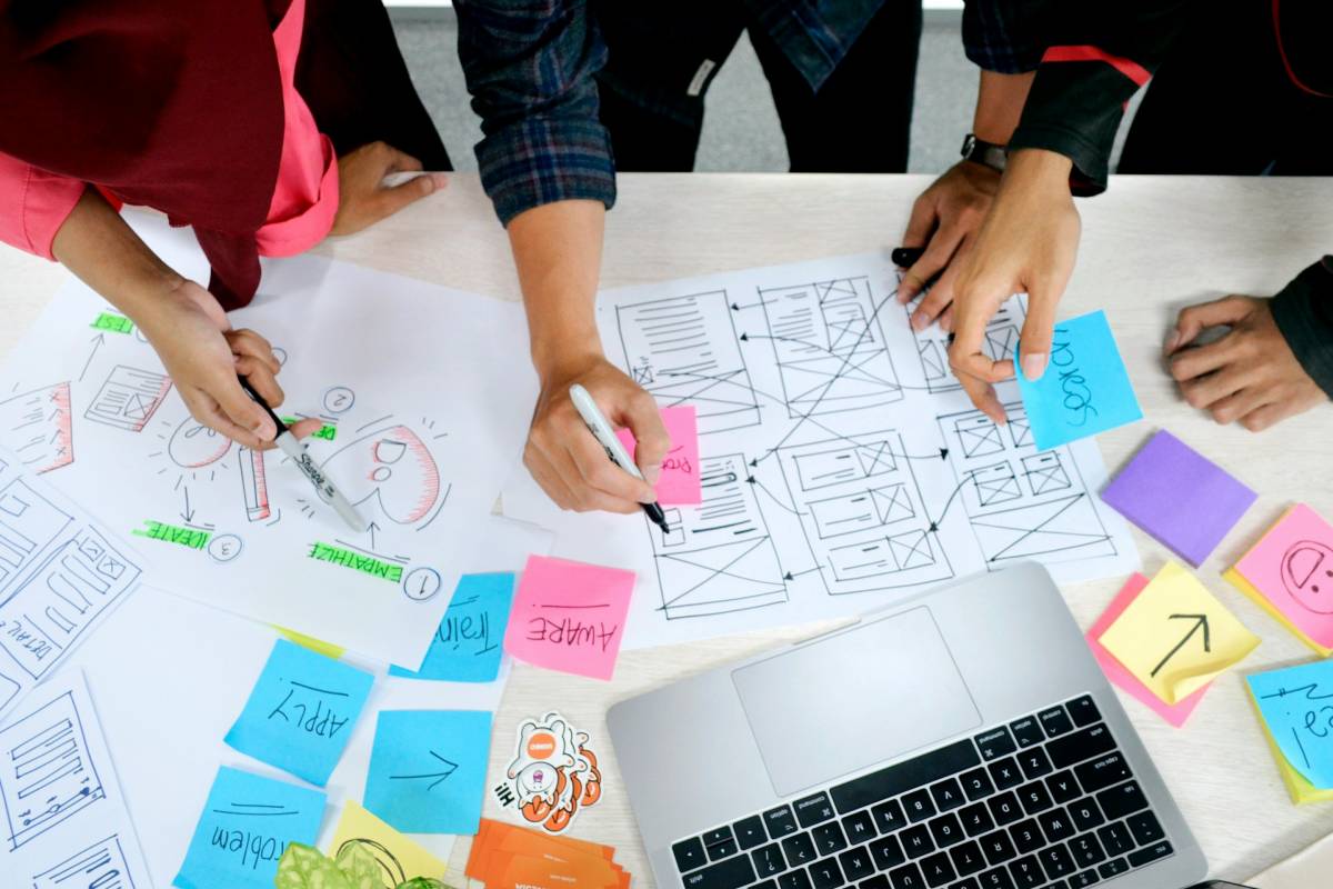 sticky notes and design wireframes spread across an office table