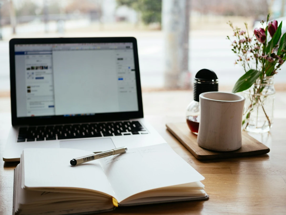 A professional workspace for legal content creation, with a laptop showing a law firm blog draft alongside legal reference materials