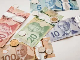Canadian paper currency and coins spread across a desk
