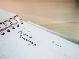 A spiral-bound notebook is open with 'Content Strategy' written on the current page