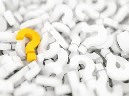 Artistic 3D rendering of a pile of three dimensional questions marks.  All of them white except for one golden question mark.