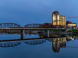 Bridge over the river in downtown Saskatoon, Saskatchewan during a vibrant sunrise.