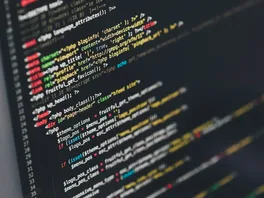 A computer screen displays colorful PHP and HTML website code